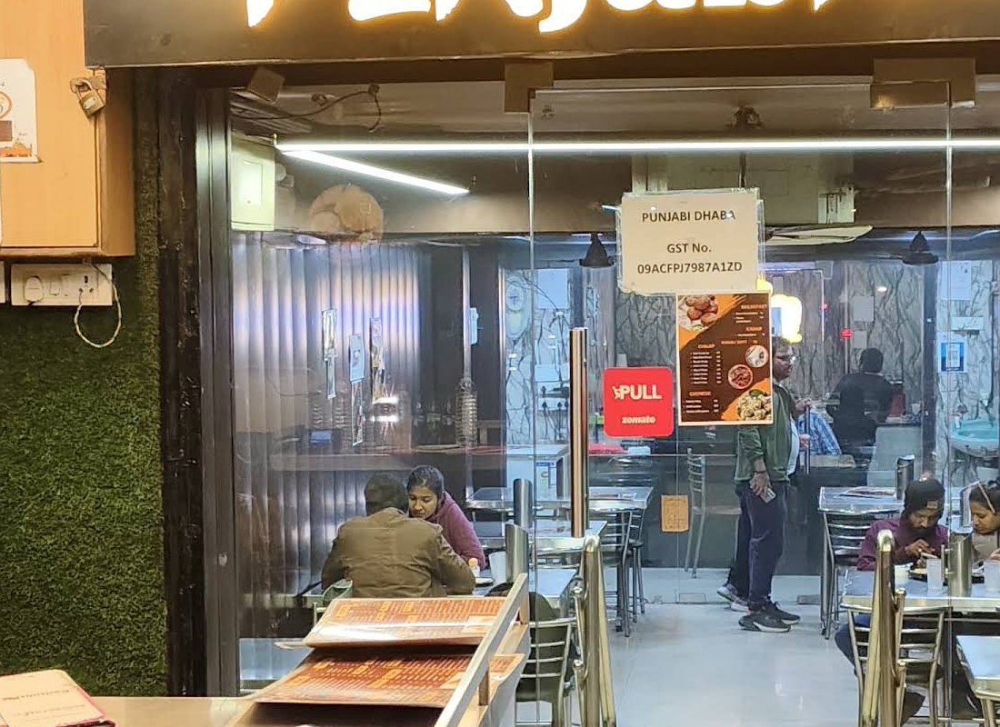 Guests dining at steel tables inside Da Punjabi Dhaba